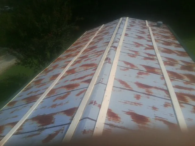Rusted metal roof panels with new wood purlins before replacement — Storm Damage Roof Repair in Esmont by Roofing Brothers