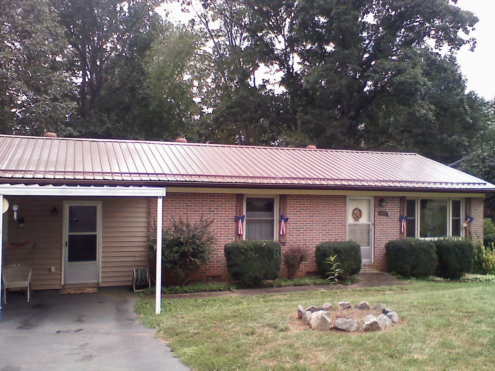 Bronze metal roof and carport on a brick ranch home — Roof Repair work by our crew in Esmont